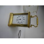 A miniature brass carriage clock and key