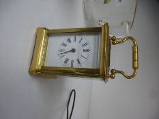 A miniature brass carriage clock and key