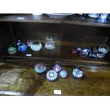 A shelf of paperweights including a Perthshire example