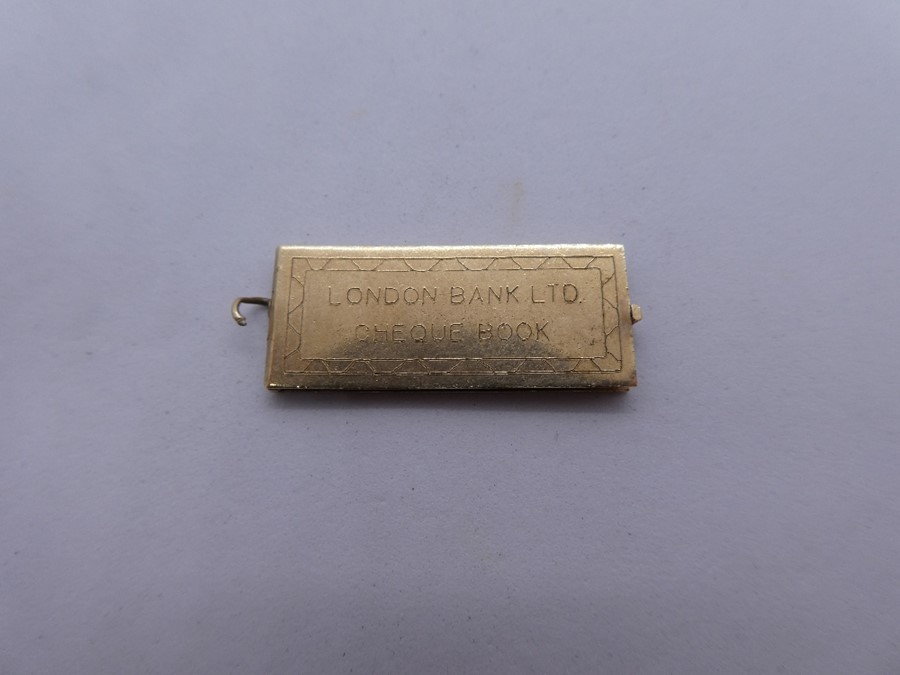 9ct yellow gold pendant marked 375, in the form of a cheque book, 'London Bank Ltd', enclosed a mini