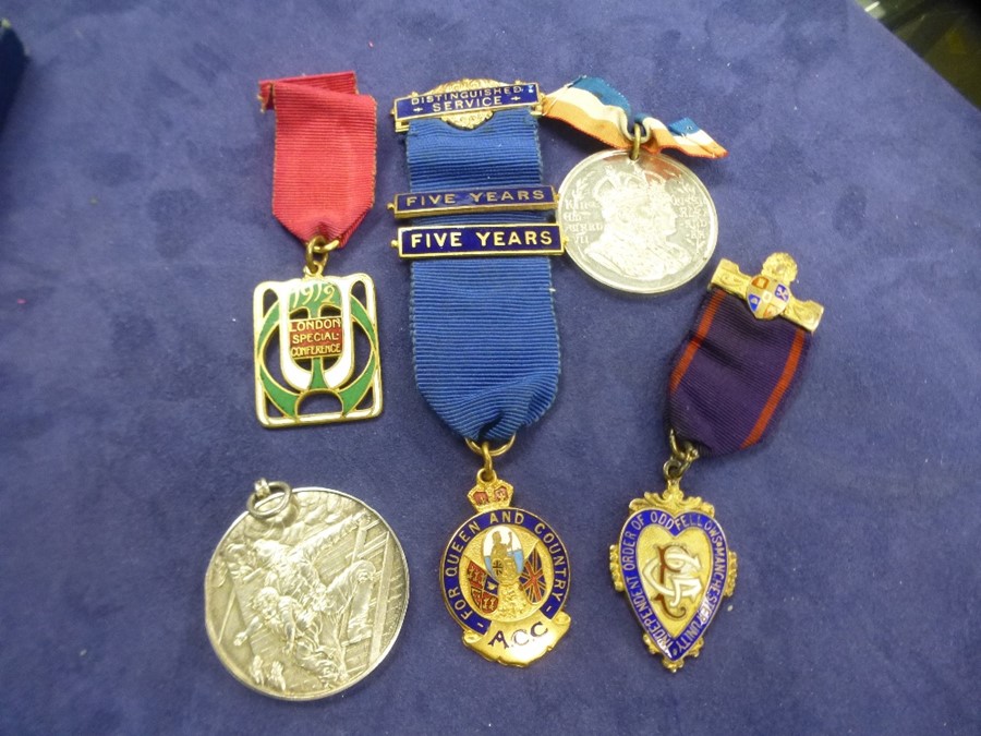 A silver medal of firefighter rescuing a child and other presentation medals