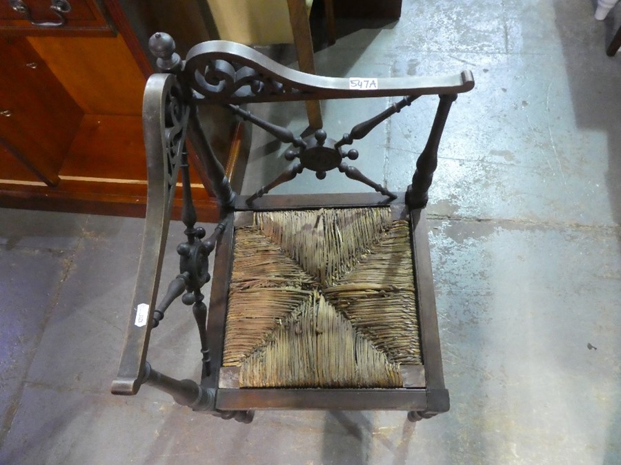 An antique mahogany corner chair with rush seat