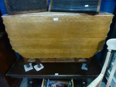 An oak gateleg dining table having wavy edge on barley twist legs