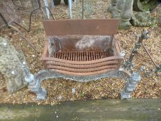 An old fire grate with pierced decoration and a pair of fire dogs