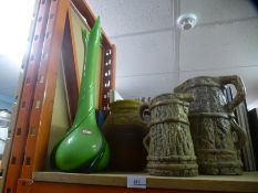 A green glass vase and three jugs