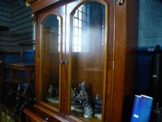 A reproduction yew wood glazed book case having one drawer with cupboard below