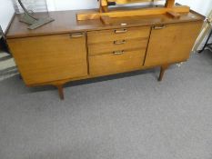 A retro teak sideboard having three central drawers