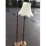 A walnut standard lamp with turned column on circular base; and another with tapering column mounted