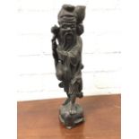 A nineteenth century Japanese carved hardwood figure of an immortal, the bearded gentleman with