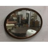 An oval Edwardian oak framed mirror with bevelled plate. (30.5in x 20.5in)