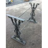 A Victorian cast iron table base with two pierced scrolled supports centering on bearded masks