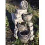 A garden feature moulded with four pots on corner of stone wall, complete with electric pump. (