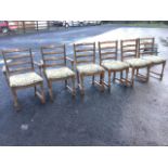 A set of six oak ladderback dining chairs including two carvers, having chisel carved pillars