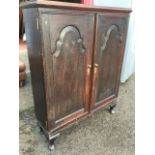 An antique oak cupboard with later restorations, having rectangular moulded top above two gothic