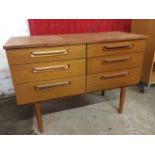 A 1960s Schreiber teak cabinet of six graduated drawers having rectangular cushion carved handles,