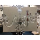 An Italian style chandelier, the faceted column with bowl terminal supporting six twisted scrolled