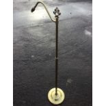 A brass standard or reading lamp with scrolled branch on circular moulded base. (56in)