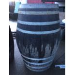 A massive oak barrel, the staves bound by eight galvanised strap bands. (50in)