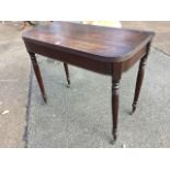 A nineteenth century mahogany turn-over-top tea table with rounded reeded corners, raised on ring-