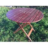 A circular folding garden table with slatted top on rectangular legs. (35.25in x 29in)