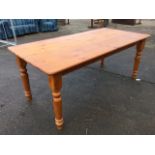 A large rectangular pine kitchen table on turned legs. (35.5in x 72in x 30in)