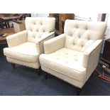 A pair of contemporary button upholstered armchairs with loose cushions and brass studding, raised