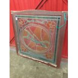 A leaded, stained and painted glass panel, mounted in frame with arched top rail, having oval