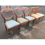 A set of three Victorian mahogany balloon-back dining chairs with drop-in upholstered seats on