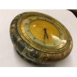 A Swiss made 1930s eight-day table clock, the circular moulded marble case on four feet mounted with