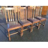 A set of four oak dining chairs, the back rails carved with loop bands above slats, having drop-in