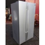 A Daewoo fridge freezer, the silvered cabinet with two doors, raised on casters. (35.25in x 28in x