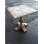 A weathered square pine table, with plate glass top having quarter panels on baluster turned column,