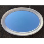 An oval Edwardian mirror in egg & dart moulded painted frame with bevelled plate.