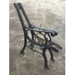 A pair of cast iron bench ends with scrolled channelled frames raised on sabre legs - need re-