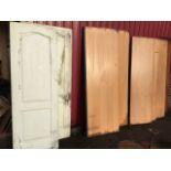 A pair of beech faced heavy fire doors; four flush board doors; and two arched fielded panelled