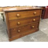 A Victorian pitch pine chest of three long knobbed drawers, supported on a plinth. (38.75in x 20in