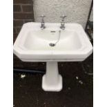 A Savoy handbasin with canted corners on shaped pedestal, mounted with Bentham chrome taps. (24.25in