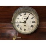 A brass cased C20th British made bulkhead clock, the face with roman chapters and secondary dial