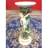 A painted jardinière stand, the circular top supported on a moulded vine trunk column with cherub,