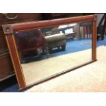 A rectangular overmantle mirror, the cushion moulded frame with crossbanded decoration, having