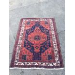 A Bokhara rug woven with serrated madder hexagonal medallion and spandrels designed with geometric