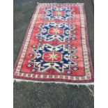 An oriental rug woven with three star medallions having serrated borders on red field, bordered by