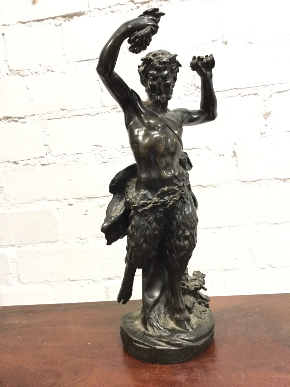 Nineteenth century bronze, Bacchus holding fruit & pestle aloft with acorn and oakleaf loincloth,