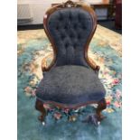 A Victorian mahogany button upholstered chair, with pierced scroll carved crest in moulded spoon