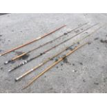 Two vintage longbows with carved horn mounts; a three-piece greenheart fly rod; a two-piece
