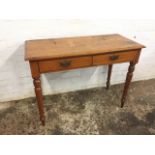 A Victorian mahogany side table with two frieze drawers mounted with brass handles, raised on turned