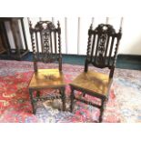 A pair of Victorian carved oak side chairs, the backs with pierced leaf & fruit crests and splats