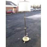 A Victorian brass oil lamp converted to a standard lamp, the reservoir on tubular column above a