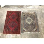 An antique oriental rug woven with central floral medallion in serrated borders on a busy ink blue