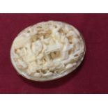 A carved ivory brooch panel with 9ct gold mount having hinged pin & safety chain, the carving